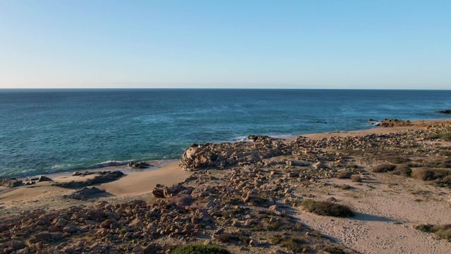BUZZARDS EAST CAPE LOS CABOS BCS MEXICO-2022: Gentle Ocean Waves Lapping Rocky Shoreline