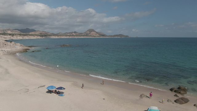 PLAYA EL ARBOLITO CABO PULMO BCS MEXICO-2022: People Walking on a Sandy Beach with Turquoise Water