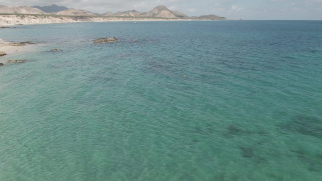 PLAYA EL ARBOLITO CABO PULMO BCS MEXICO-2022: Person Walking on Sandy Beach with Turquoise Water