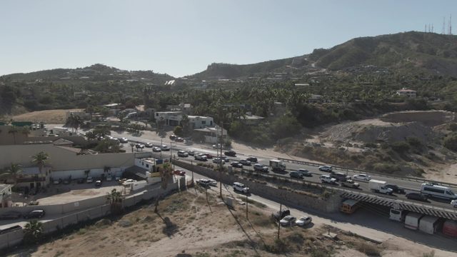 COSTA AZUL LOS CABOS BCS MEXICO-2022: Highway Traffic Moving Past Commercial Building and Parking Lot