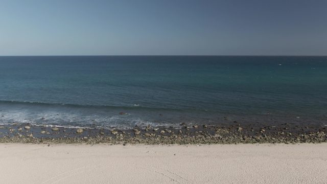 COSTA AZUL LOS CABOS BCS MEXICO-2022: Gentle Ocean Waves Rolling Onto Rocky Shore
