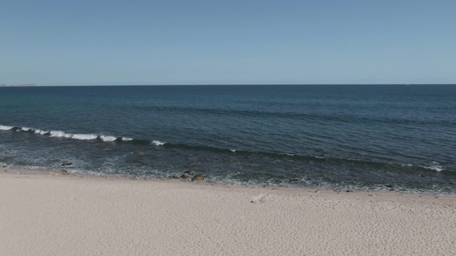 BUZZARDS EAST CAPE LOS CABOS BCS MEXICO-2022: Gentle Ocean Waves Rolling Onto Sandy Shore