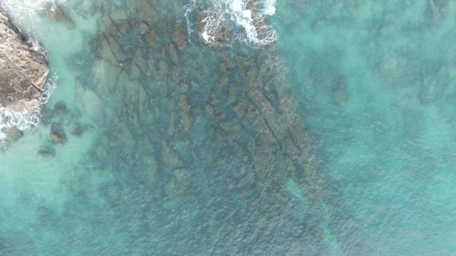 BUZZARDS EAST CAPE LOS CABOS BCS MEXICO-2022: Waves Breaking on Rocky Shore in Clear Water