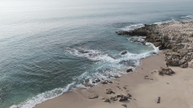 BUZZARDS EAST CAPE LOS CABOS BCS MEXICO-2022: Waves Crashing on Rocky Shore with Sandy Beach