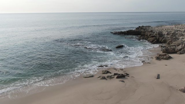 BUZZARDS EAST CAPE LOS CABOS BCS MEXICO-2022: Gentle Ocean Waves on Rocky Sandy Shore