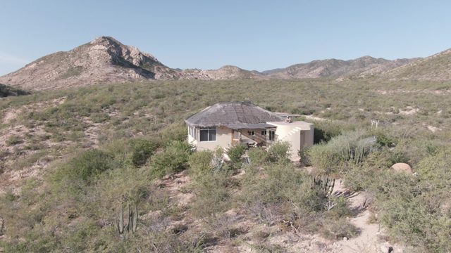 CABO PULMO BCS MEXICO-2022: Desert House Surrounded by Sparse Vegetation and Mountains