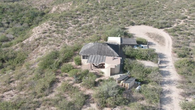 CABO PULMO BCS MEXICO-2022: Car Moving Along Desert Dirt Road near Round Structure