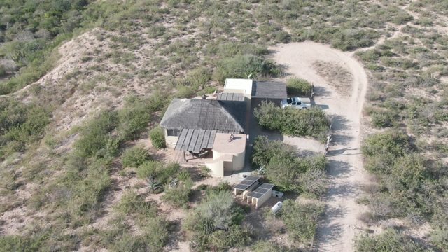 CABO PULMO BCS MEXICO-2022: Truck Driving Past Desert House on Dirt Road