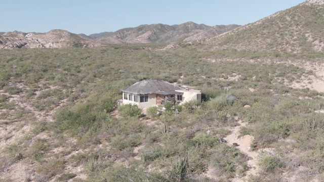 CABO PULMO BCS MEXICO-2022: Desert House Surrounded by Sparse Vegetation and Mountains