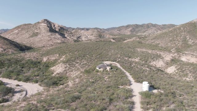 CABO PULMO BCS MEXICO-2022: Eagle Soars Over Desert Landscape With Structures