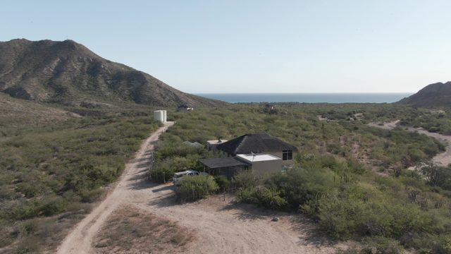CABO PULMO BCS MEXICO-2022: Car Traveling on Desert Road Toward House