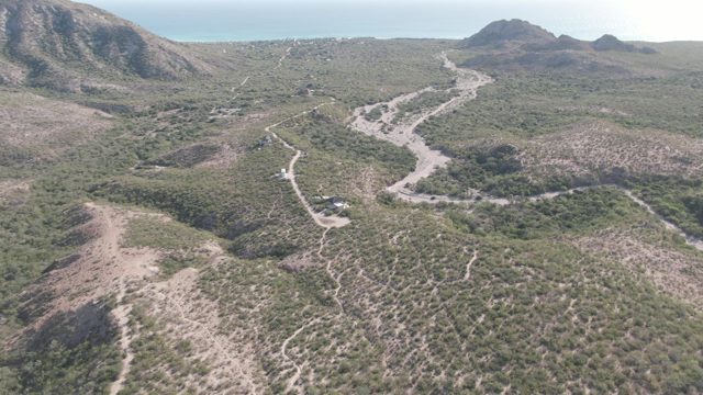 CABO PULMO BCS MEXICO-2022: Car Driving on Winding Dirt Road Through Hilly Landscape