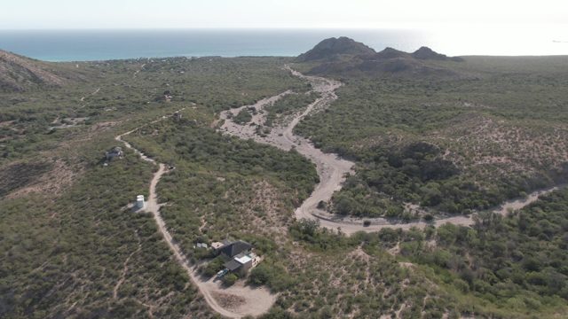 CABO PULMO BCS MEXICO-2022: Vehicle Traveling on Winding Dirt Road in Coastal Hills
