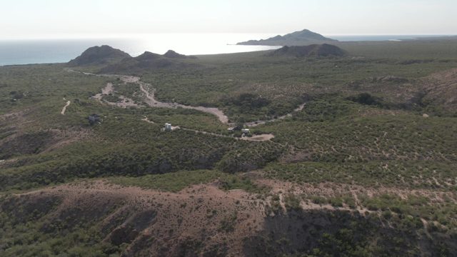 CABO PULMO BCS MEXICO-2022: Vehicle Moving Along Winding Coastal Road in Hilly Landscape