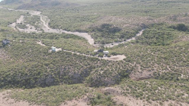 CABO PULMO BCS MEXICO-2022: Vehicles Moving Along Winding Dirt Road on Hilly Terrain