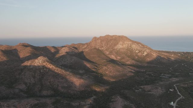 CABO PULMO BCS MEXICO-2022: Car Moving Along Mountain Road at Sunset