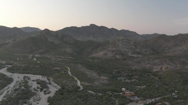 CABO PULMO BCS MEXICO-2022: Vehicle Moving Through Dry Riverbed in Mountain Valley