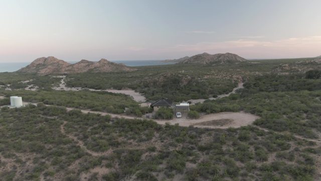 CABO PULMO BCS MEXICO-2022: Desert Landscape with Small Building and Van Departing
