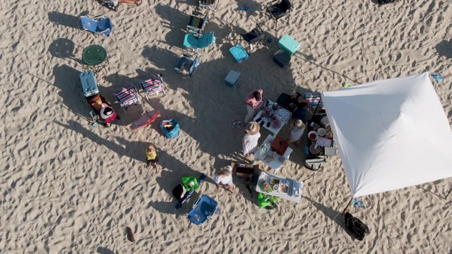 SHIPWRECKS BEACH EAST CAPE LOS CABOS BCS MEXICO-2022: Beachgoers Moving and Arranging Items on Sandy Beach