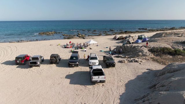 SHIPWRECKS BEACH EAST CAPE LOS CABOS BCS MEXICO-2022: Sandy Beach with Parked Vehicles and People Gathering