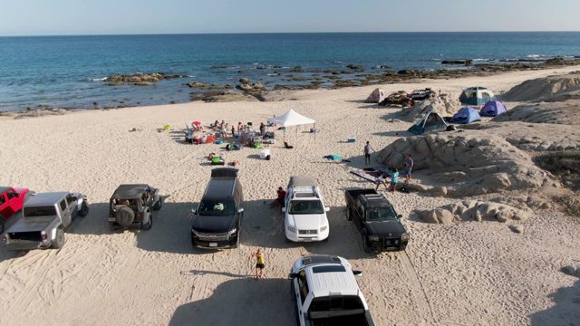 SHIPWRECKS BEACH EAST CAPE LOS CABOS BCS MEXICO-2022: Parked Trucks and People on Sandy Beach
