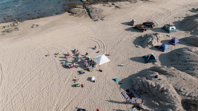 SHIPWRECKS BEACH EAST CAPE LOS CABOS BCS MEXICO-2022: People Gathering on Sandy Beach with Tents and Vehicles