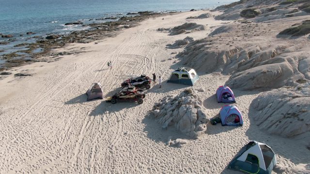 SHIPWRECKS BEACH EAST CAPE LOS CABOS BCS MEXICO-2022: Beach Campsite with People Moving Near Tents