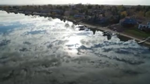 HIDDEN LAKE COLORADO-2016: Flying Over a River Reflecting the Sky and Clouds