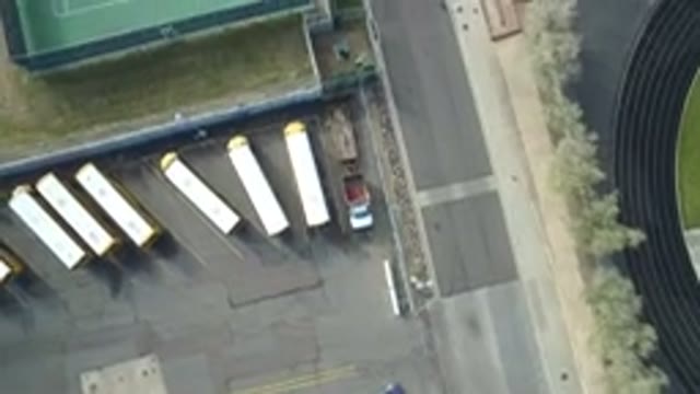 HIDDEN LAKE COLORADO-2016: Many Buses in a Large Parking Lot Next to a Tennis Court