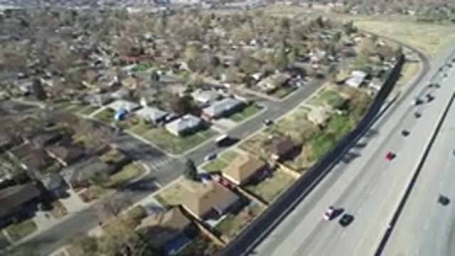HIDDEN LAKE COLORADO-2016: Cars Driving On A Highway With A Community On The Side
