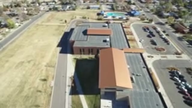 WESTMINSTER COLORADO-2016: Drone Flying Over A Big Building With A Parking Lot