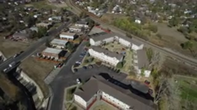 WESTMINSTER COLORADO-2016: Buildings By A Straight Curve Road With Cars Parked