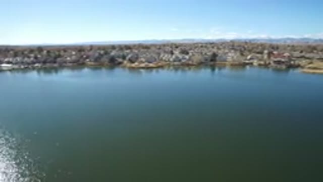 WESTMINSTER COLORADO-2016: Plane Flying Across Clear Sea Water With City The