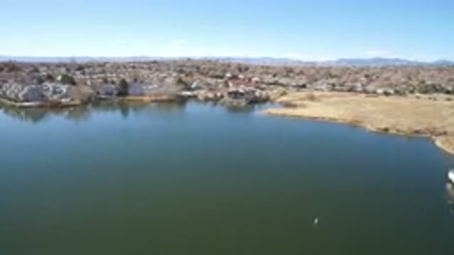 WESTMINSTER COLORADO-2016: Big Lake With Greenish Water A Street Where Some Cars