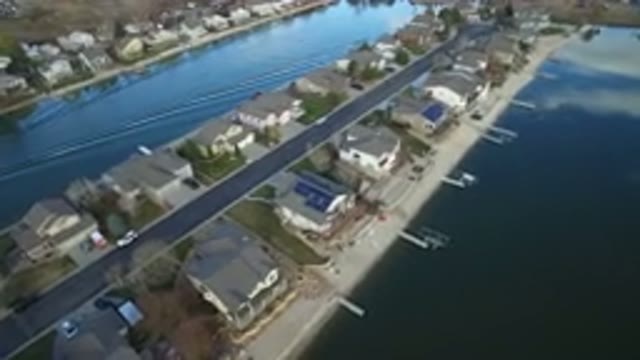 WESTMINSTER COLORADO-2016: A Boat Creates A Wake In A Channel Next To The Street