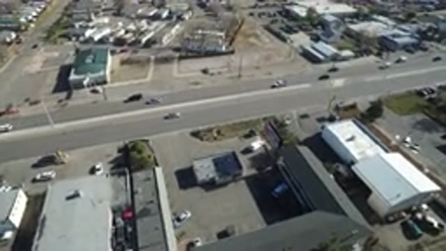 WESTMINSTER COLORADO-2016: Cars Driving On Road In Small Town Past An Industrial