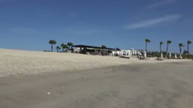 SAN JOSE DEL CABO MEXICO-2017: Windy Day At The Beach Waves Building's Flag In