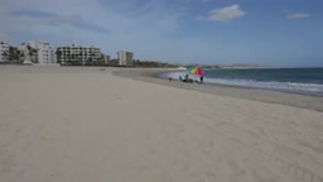 SAN JOSE DEL CABO MEXICO-2017: People Sit And Play Around A Beach Umbrella On A