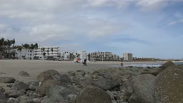 SAN JOSE DEL CABO MEXICO-2017: Several People At The Beach With Rocks In The Foreground