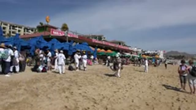 CABO SAN LUCAS MEXICO-2017: People Roaming the Beach Man Selling Hats