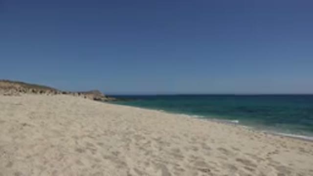 LOS CABOS MEXICO-2017: Beautiful Blue Green Waves Gently Wash Up On The Sandy Shore