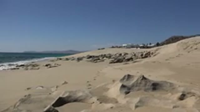 LOS CABOS MEXICO-2017: Plane Flying Above A Beach With Sand On The Ground And