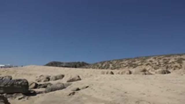 LOS CABOS MEXICO-2017: Sand Small And Large Rock Low Hills Clear Blue Sky