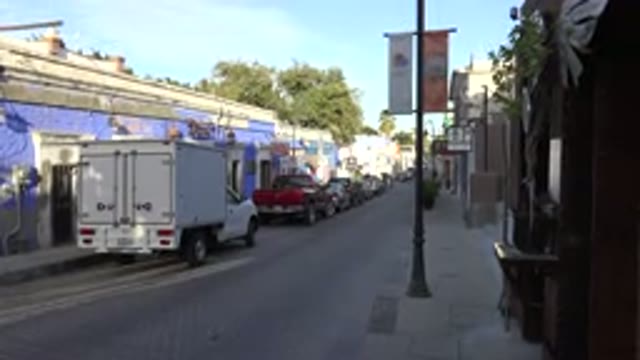 LOS CABOS MEXICO-2017: Car Slowly Passing a Stationary Camera on a Narrow Town Road