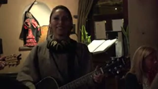 LOS CABOS MEXICO-2017: Woman Playing Guitar in Front of Crowd Inside Building