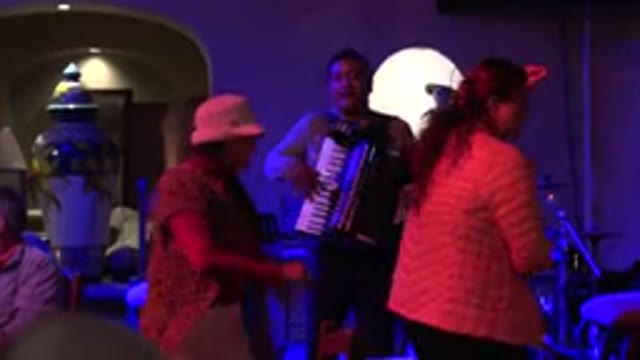 LOS CABOS MEXICO-2017: Two Women Having A Good Time Dancing To A Man Playing An