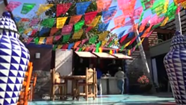LOS CABOS MEXICO-2017: Shop With Hanging Colored Cloths And Big Blue Pots