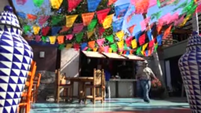 LOS CABOS MEXICO-2017: Open Place Colorful Flags Blue White Vases Man Walking