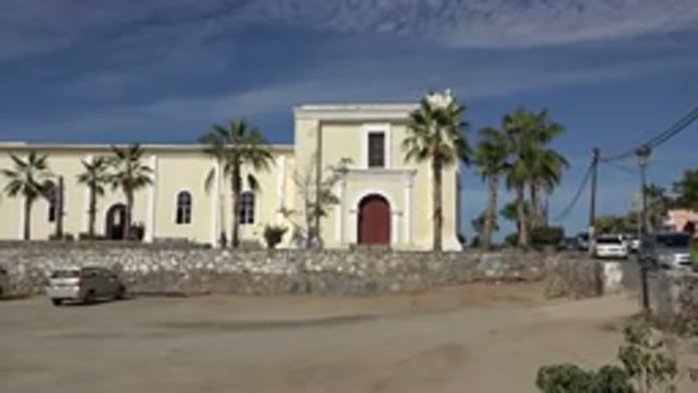 LOS CABOS MEXICO-2017: People Walking Near Large Pale Building With Arched Dark Doorways