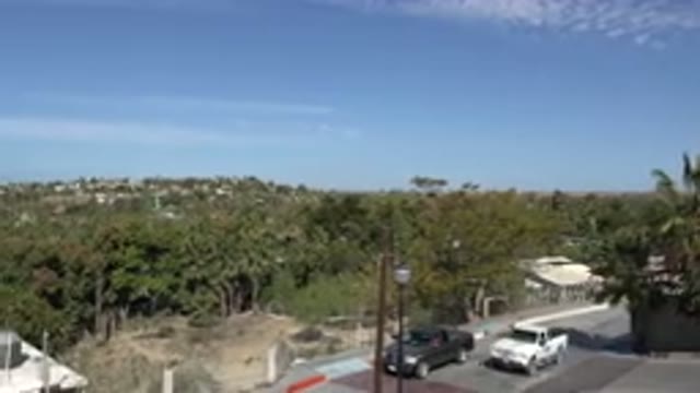 LOS CABOS MEXICO-2017: A White Pickup Truck Drives Up A Street Flanked With